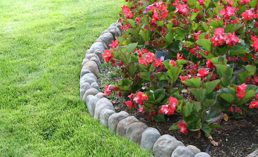 Edging stones installed between a flower bed and lawn.