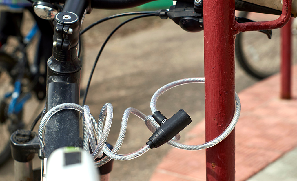 A bike secured to a rack with a cable lock.