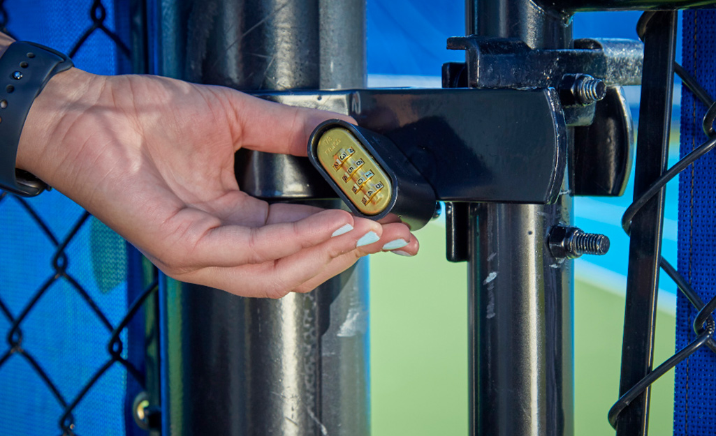 A person locking a set-your-own-combination lock.