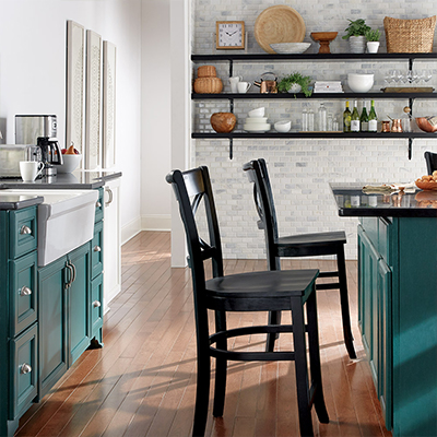 Farmhouse-style kitchen cabinets painted in a green tone. 