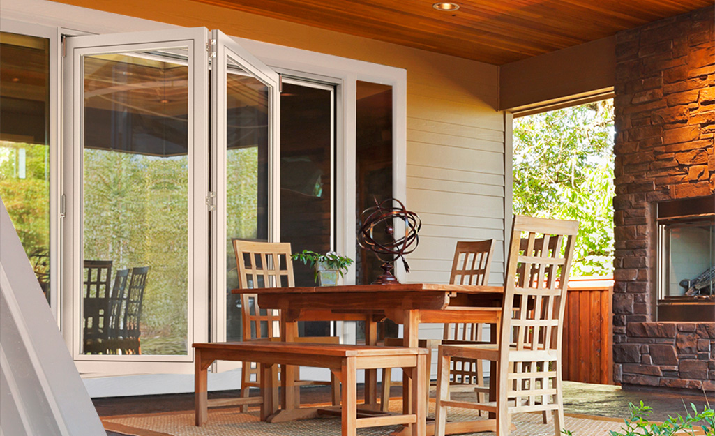 A folding patio door on a patio with wood and brick trim.