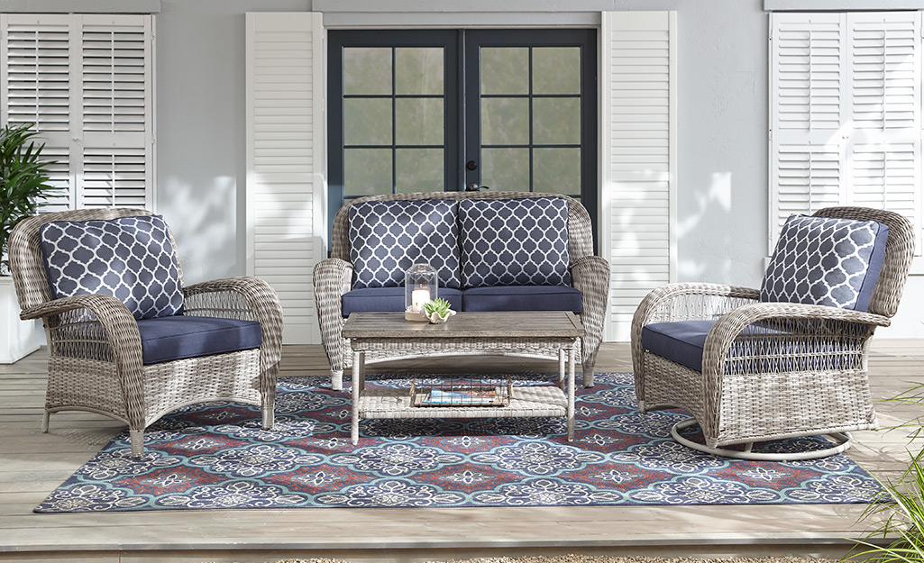Wicker lounge chairs, love seat and coffee table on a large patio. Wicker lounge chairs, love seat and coffee table on a large patio.