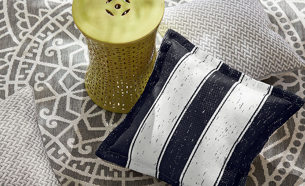 Pillows and other patio accessories on a gray and white rug. Pillows and other patio accessories on a gray and white rug.