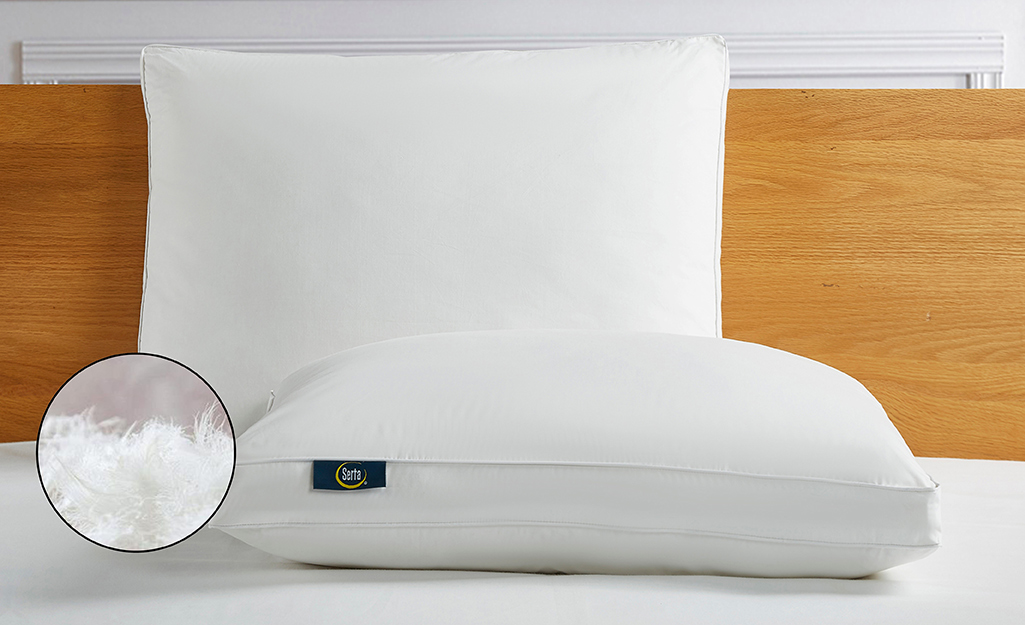 A down pillow placed on a bed.