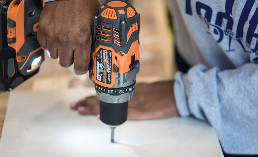 A person using a drill-driver.