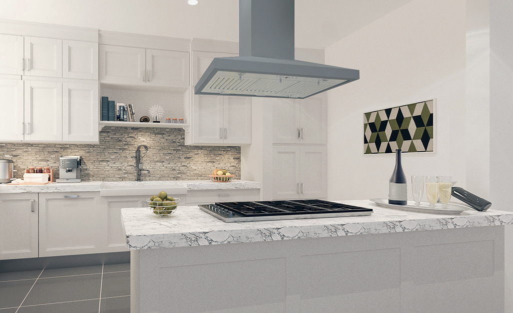 A ceiling-mounted range hood installed over a cooktop on a kitchen island.