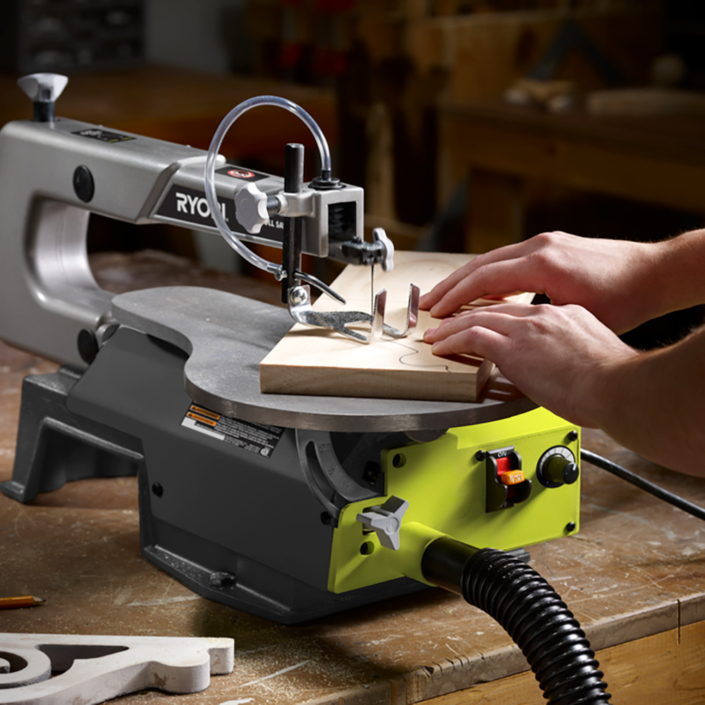 A person using a scroll saw to cut wood.