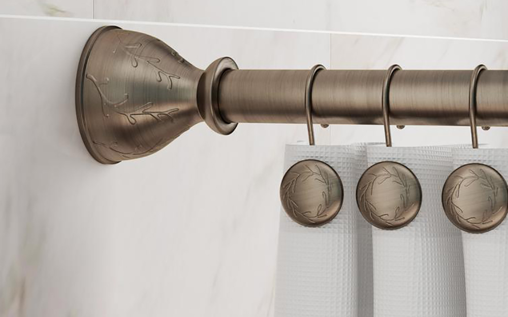 A close up image of a stainless steel shower curtain rod and hanging hooks