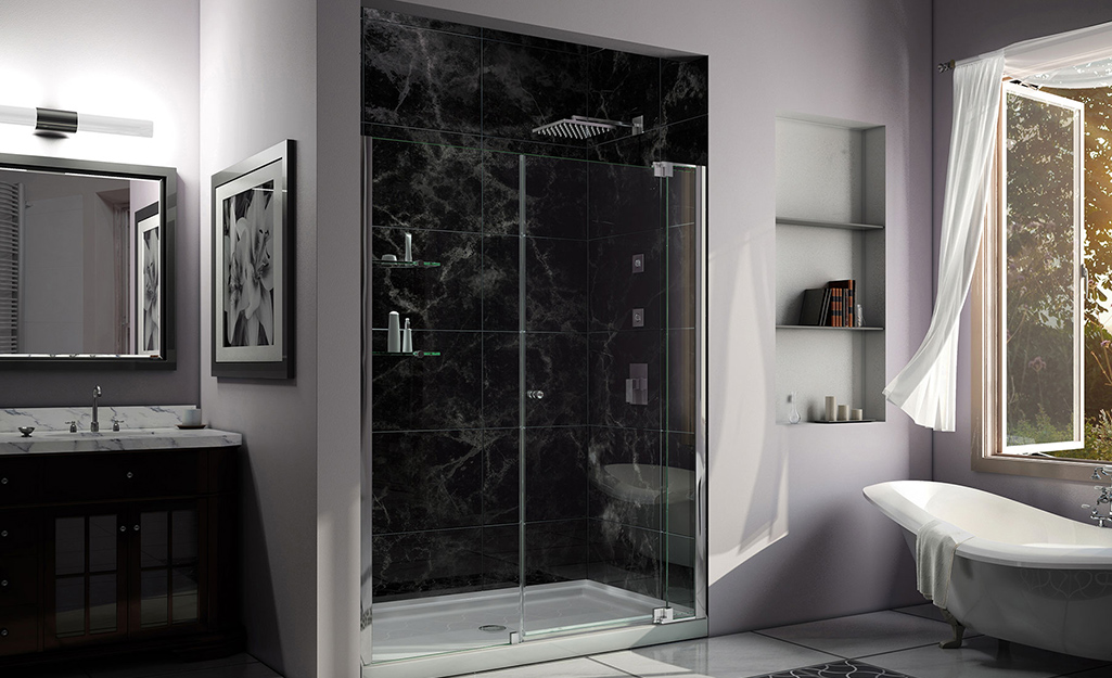 An alcove shower with black tile walls and a white base.