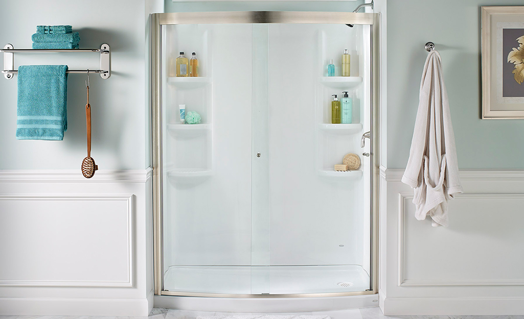 An alcove shower with built-in wall shelves.