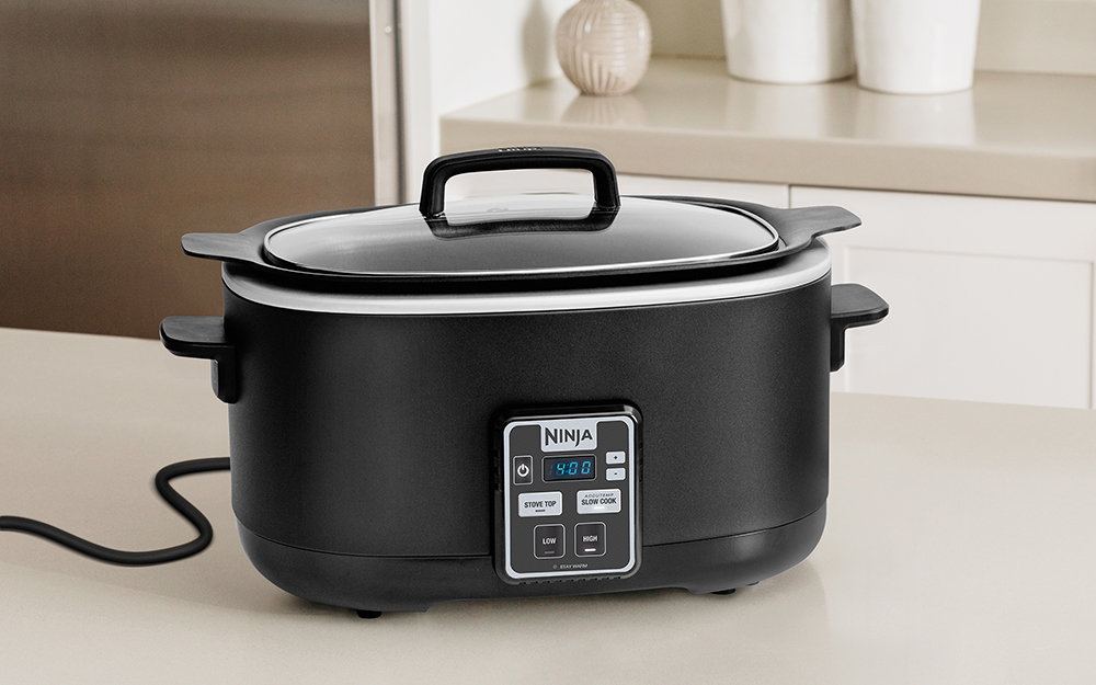 A black slow cooker on a counter.
