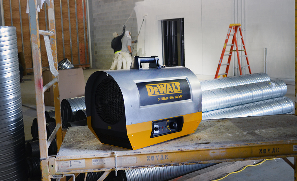 A fan heater sitting on a work table.