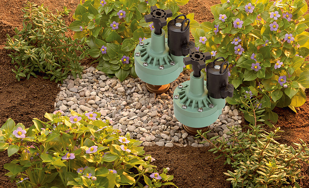 A green sprinkler in a garden.