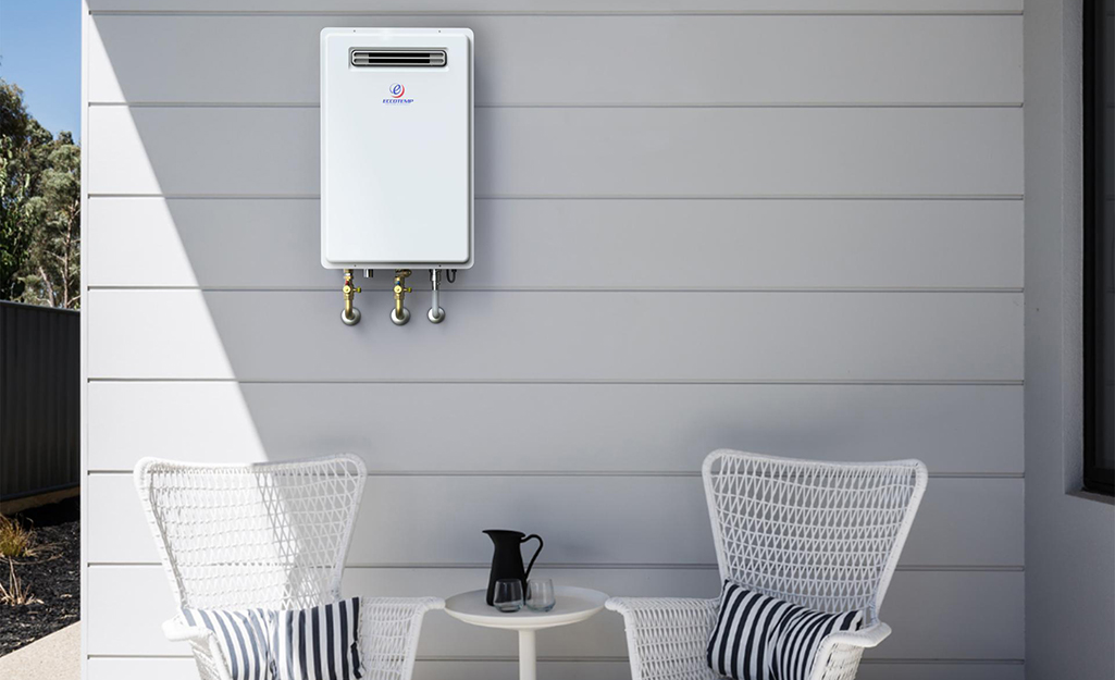 A tankless gas water heater hangs on the wall of a living room.