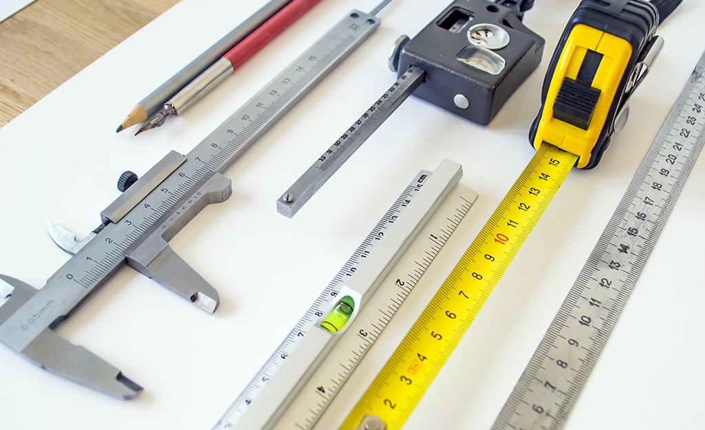 Different types of tape measures and measuring tools on a table.