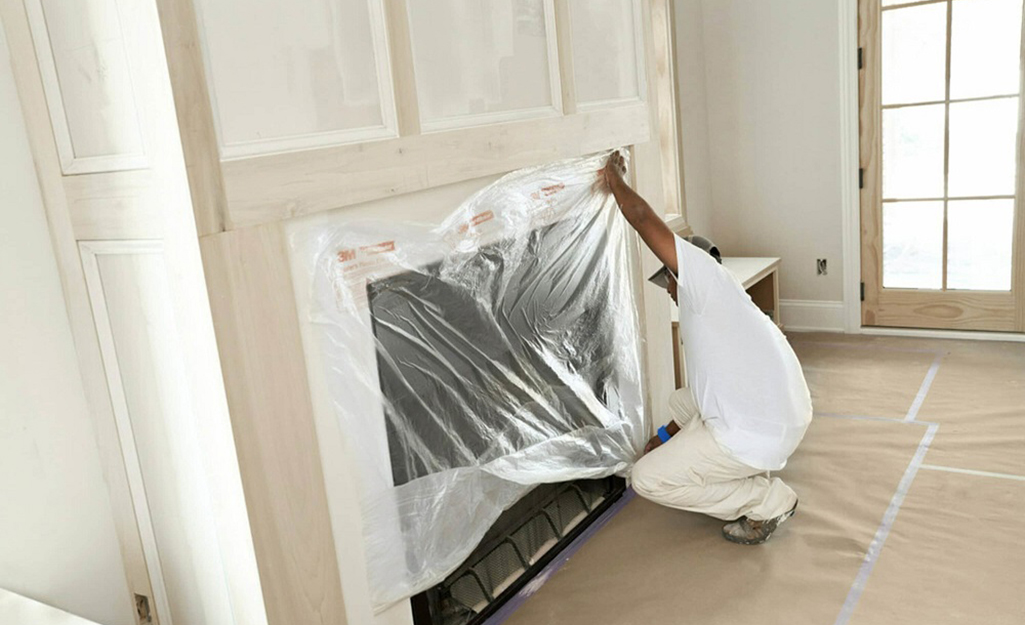 A plastic sheet covers a fireplace. 