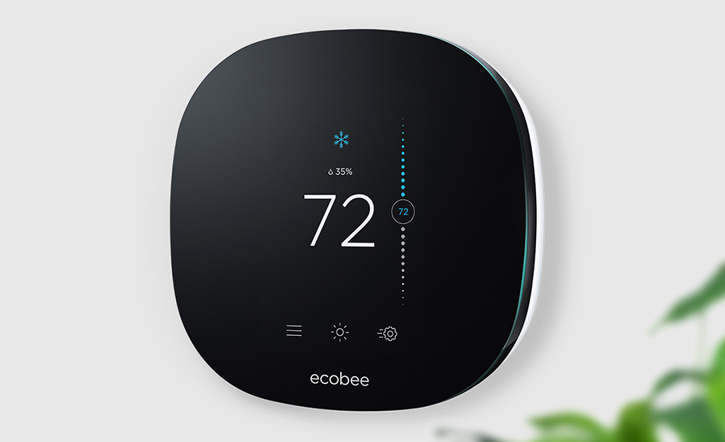 A programmable thermostat on a wall in a home.