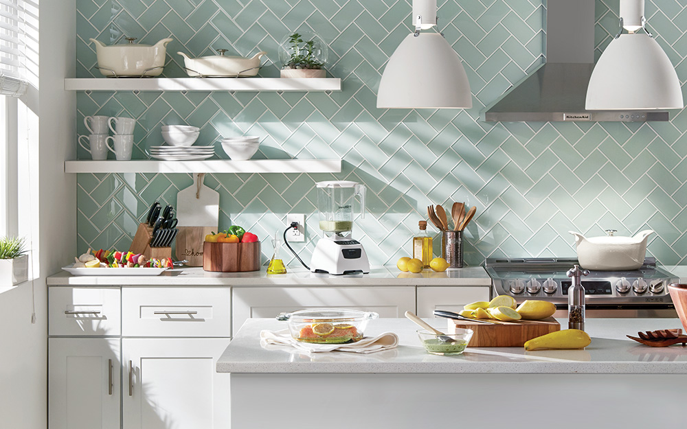 A kitchen with light green ceramic tile backsplash. 