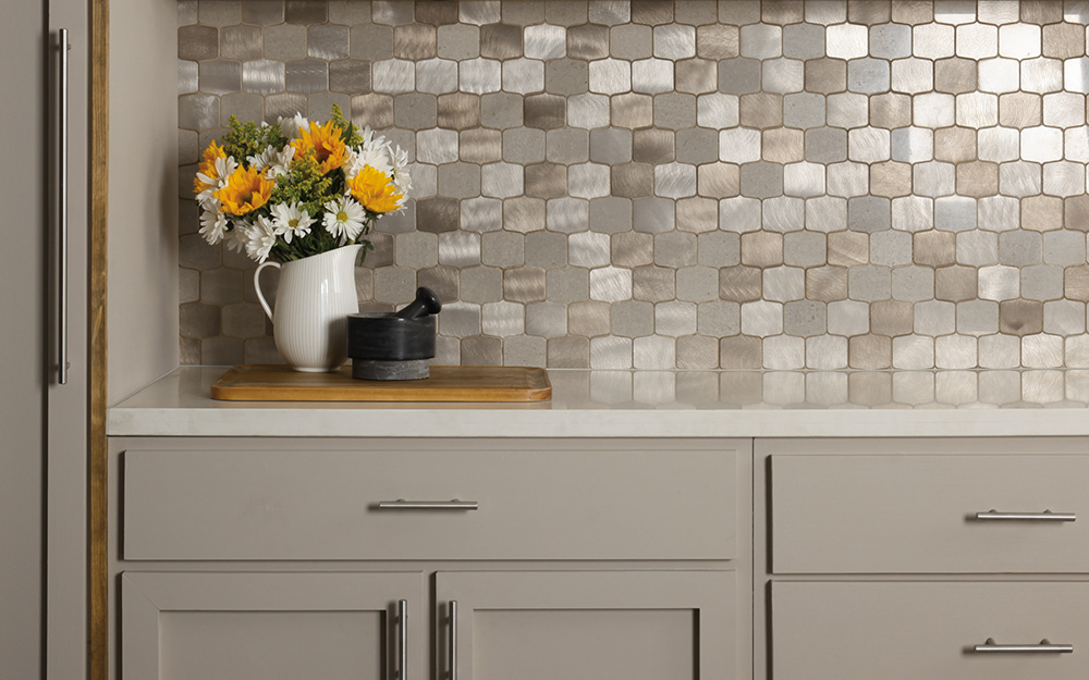 A kitchen wall with metal backsplash. 