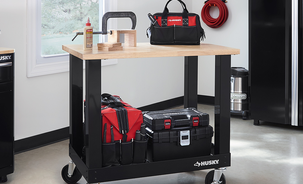 A cart displays an assortment of tool belts, bags and pouches.