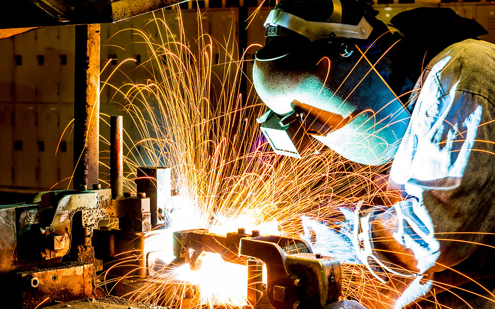 A person wearing a welding helmet with welding goggles