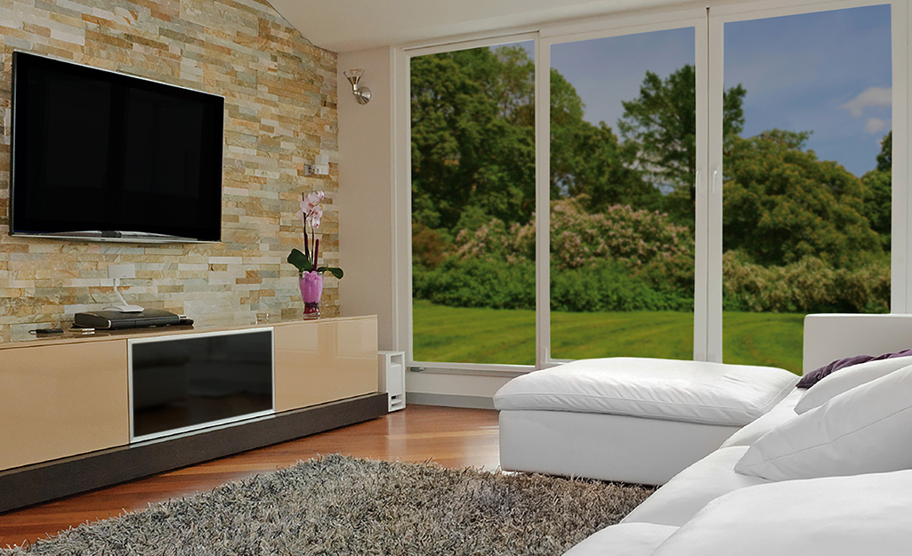 Temperature control window film covering floor-to-ceiling windows in a home.