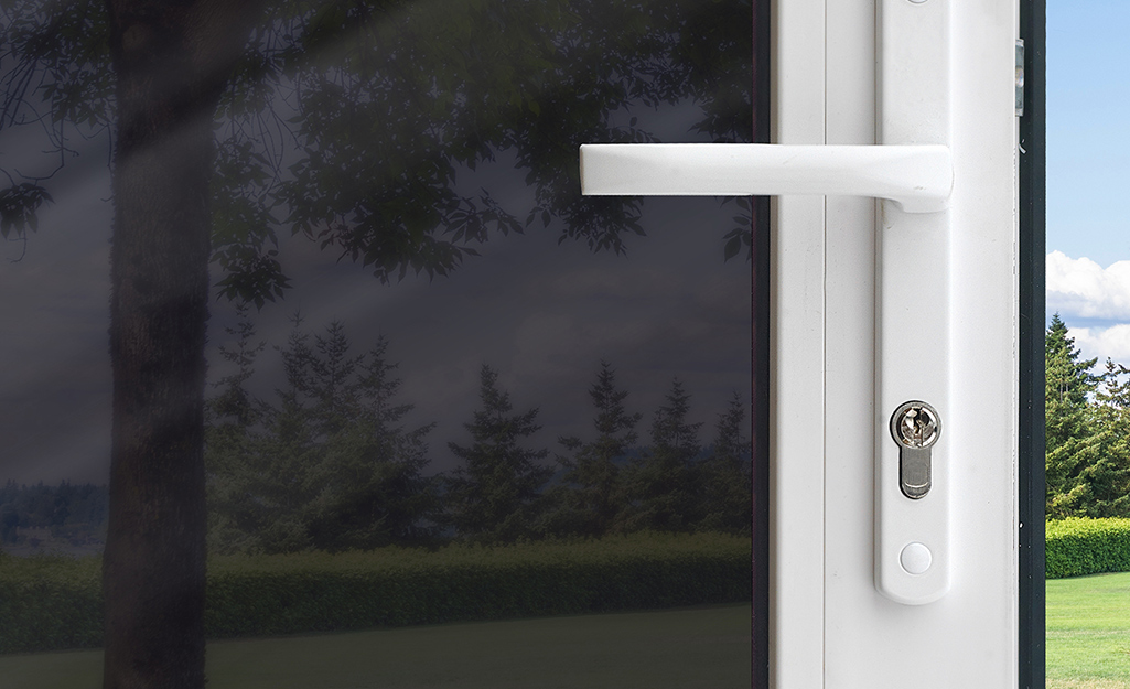 Close-up of a glass exterior door covered with dark security film