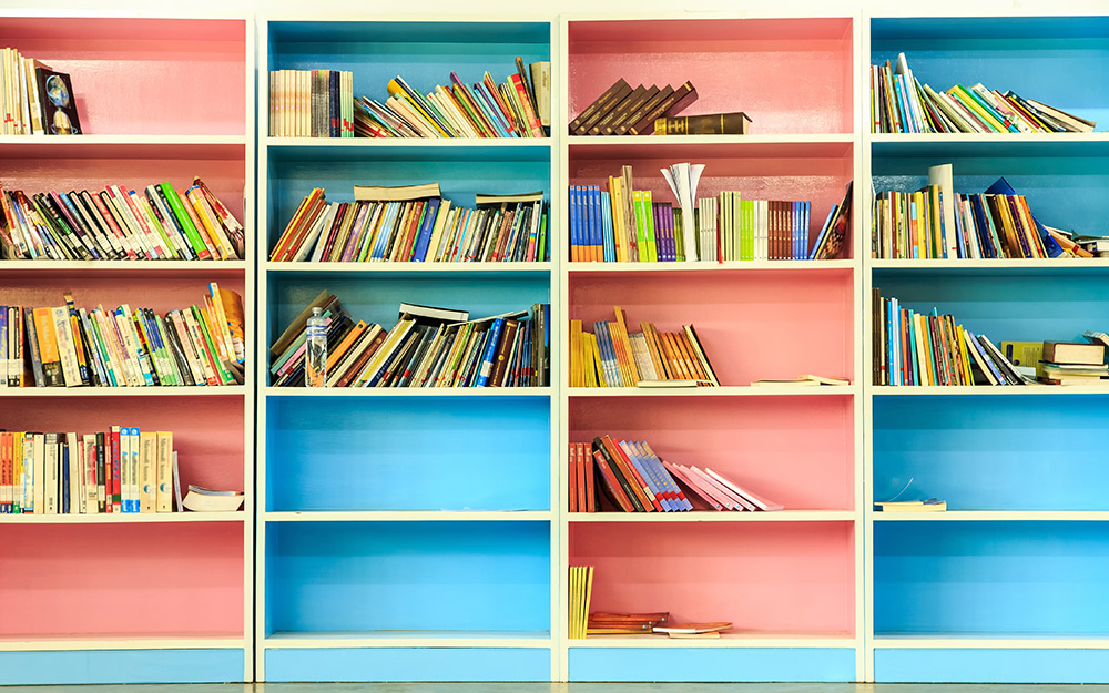 Bookcases painted in alternating colors of pink and blue.