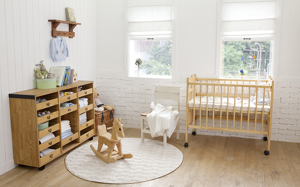 A boy's nursery with neutral paint colors and a light wood floor.