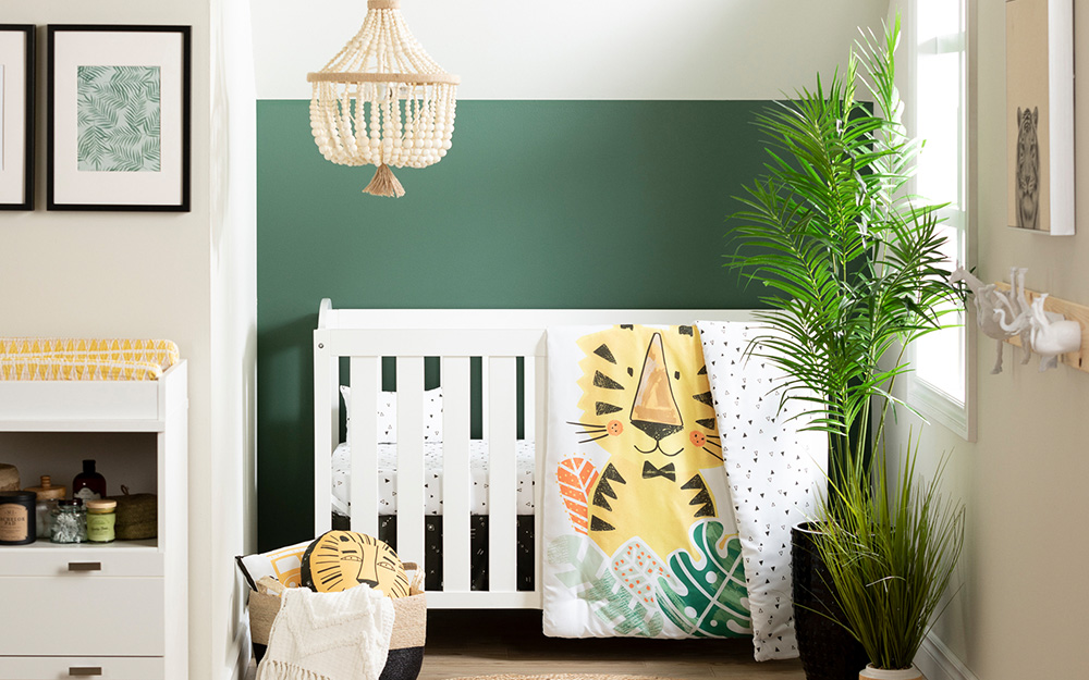 A boy's nursery with a jungle theme in gold, white and green.