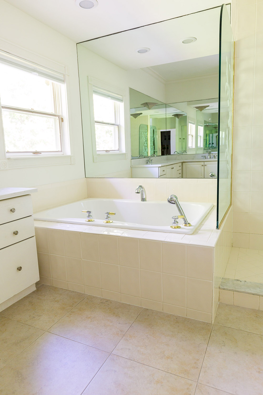 A bathroom with a mirrored wall before the makeover.