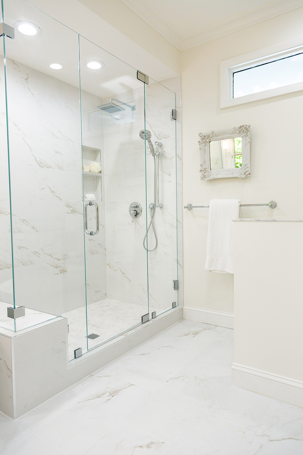 An updated large walk-in shower with large format porcelain tile walls and floors.