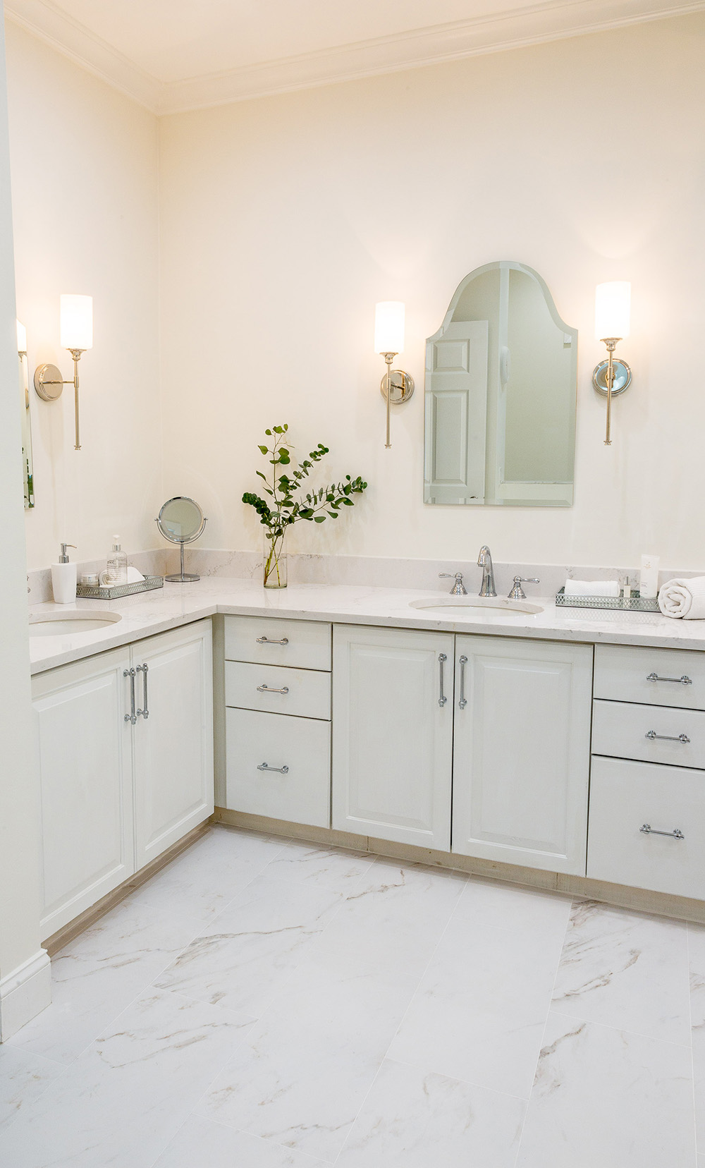 A white L-shaped double vanity with new chrome hardware.