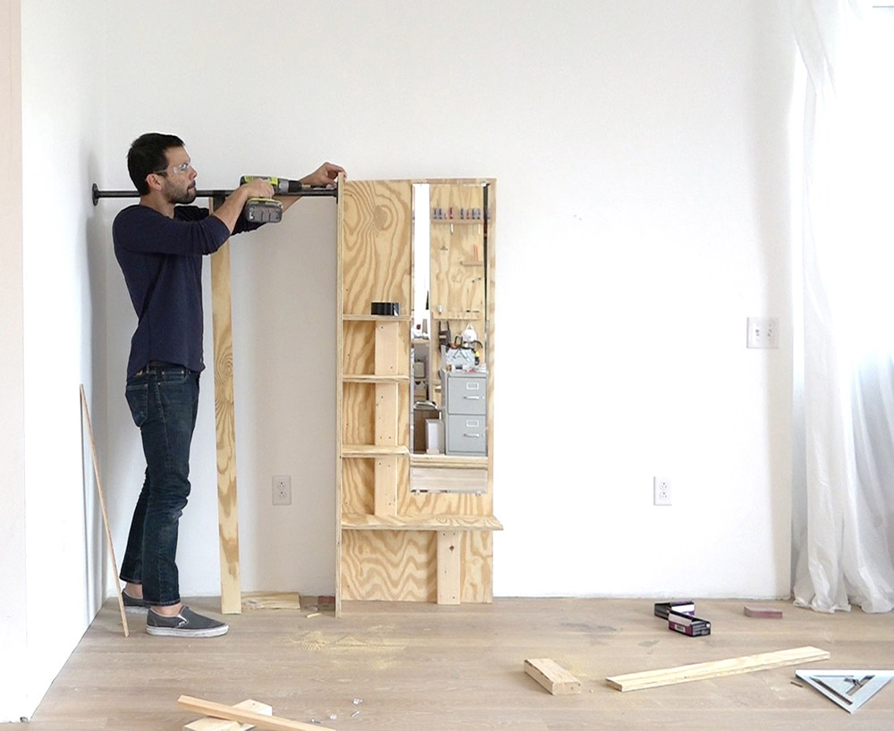 A person adding clothes hanging bar