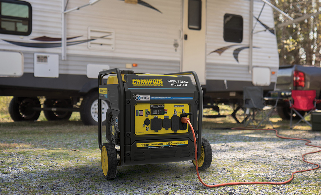 A white RV plugged into a large inverter generator.