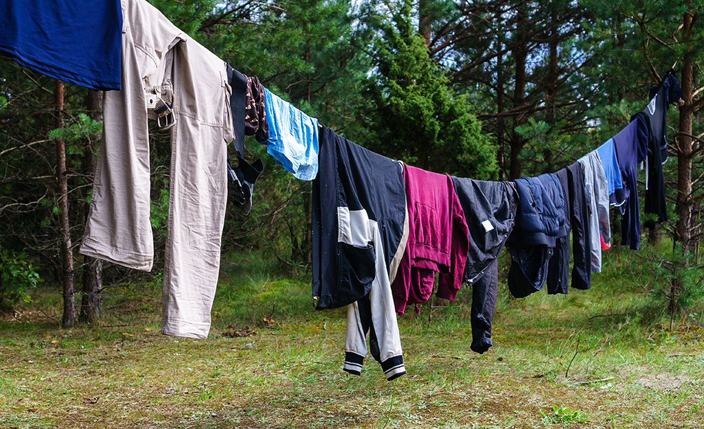Clothes hang on a clothesline near a campsite.