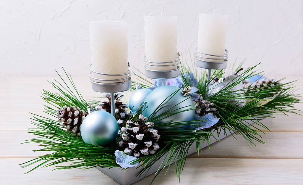 Candles and blue ornaments in a metal tray.