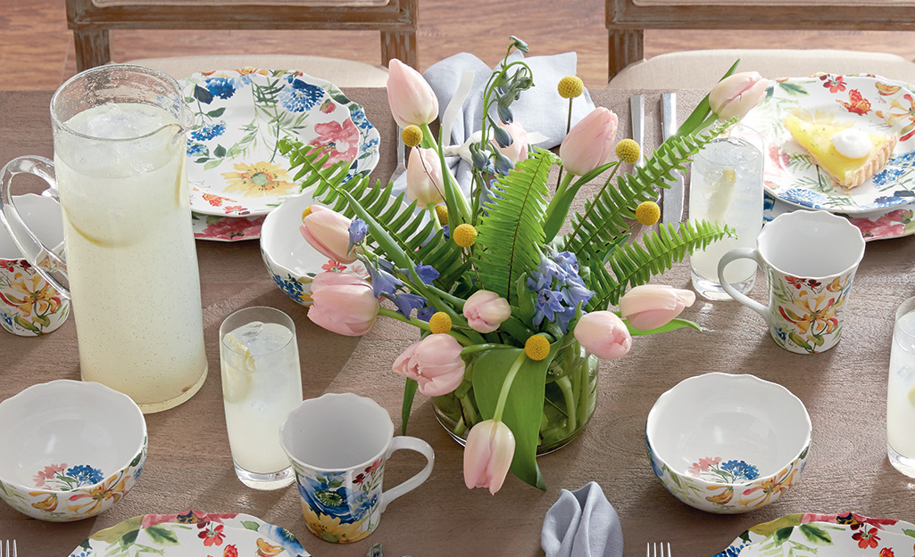 A vase with pink tulips on a table.