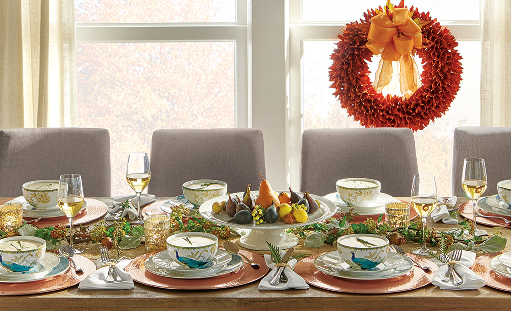 A dining table with fall themed decorations.