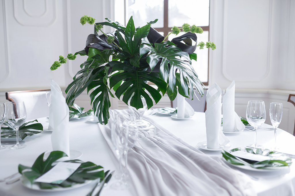 Large palm leaves in a vase on a table.