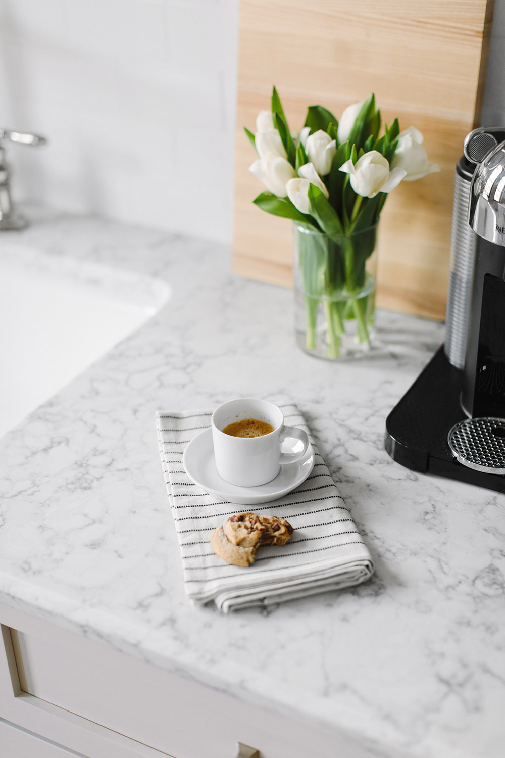 A white quartz countertop with a cup of coffee and a cookie. A white quartz countertop with a cup of coffee and a cookie.