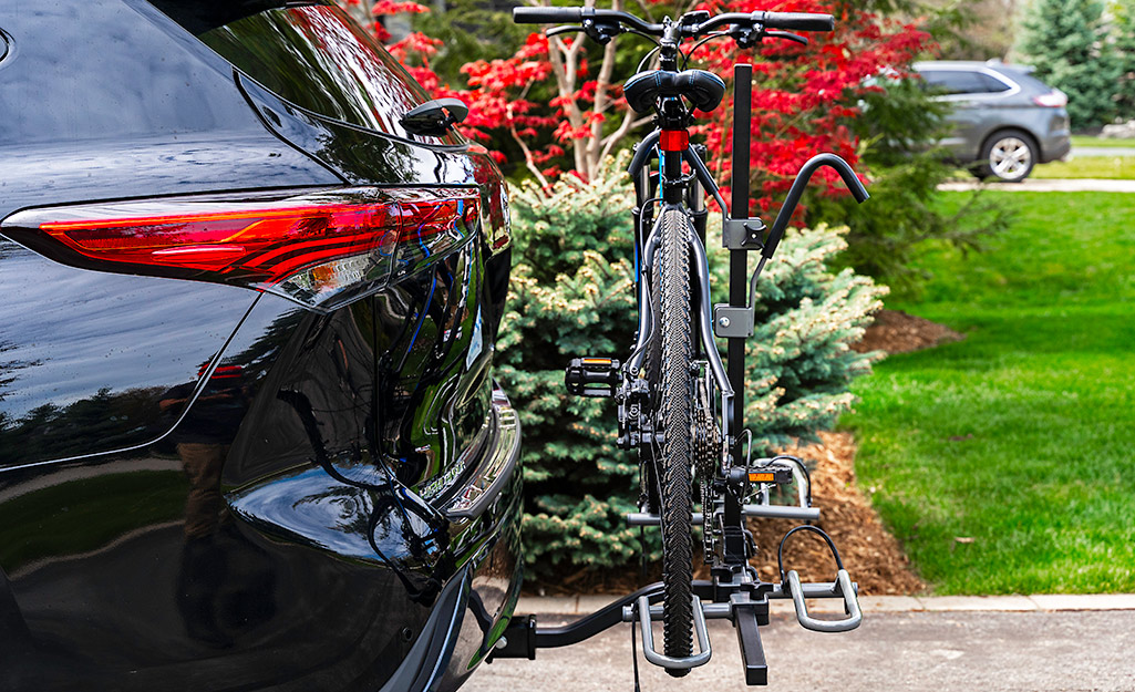 A car features a hitch-mounted bike rack.