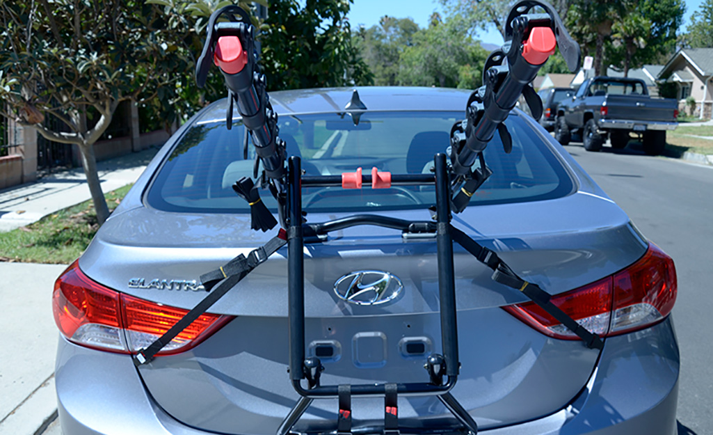 A car features a trunk-mounted bike rack.