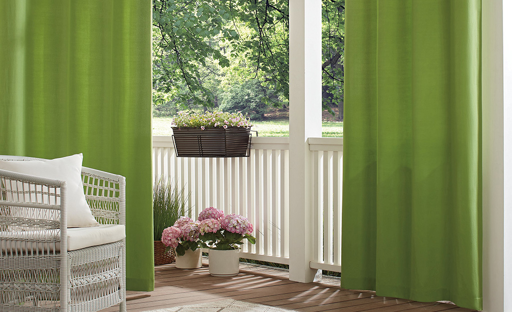 An outdoor patio featuring green outdoor curtains
