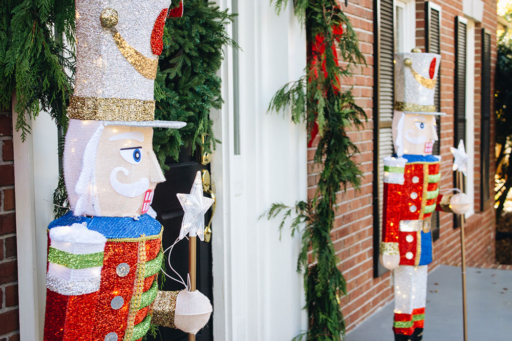 The side view of two nutcrackers standing guard at a holiday front porch.