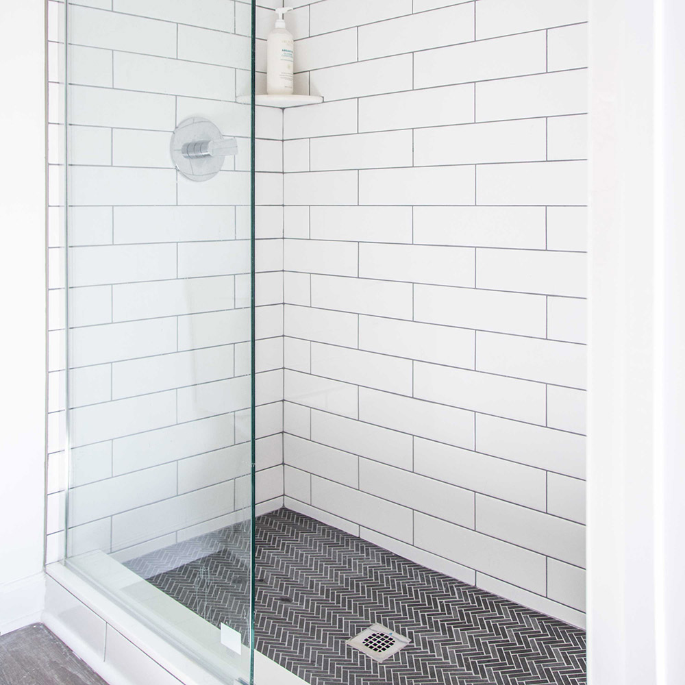 A shower with white subway tile.