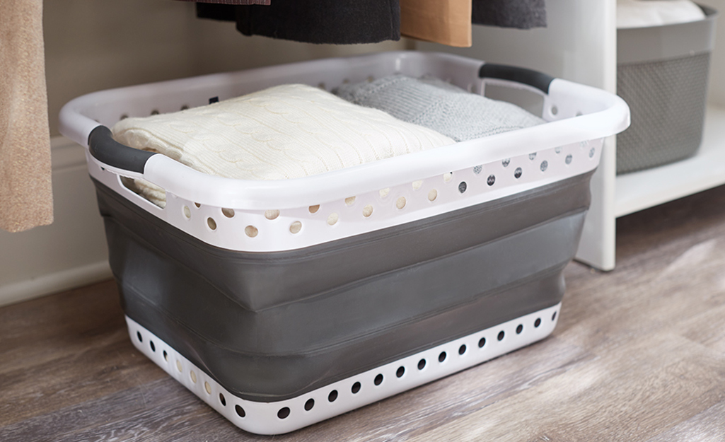 A collapsible storage bin with miscellaneous linens inside. A collapsible storage bin with miscellaneous linens inside.