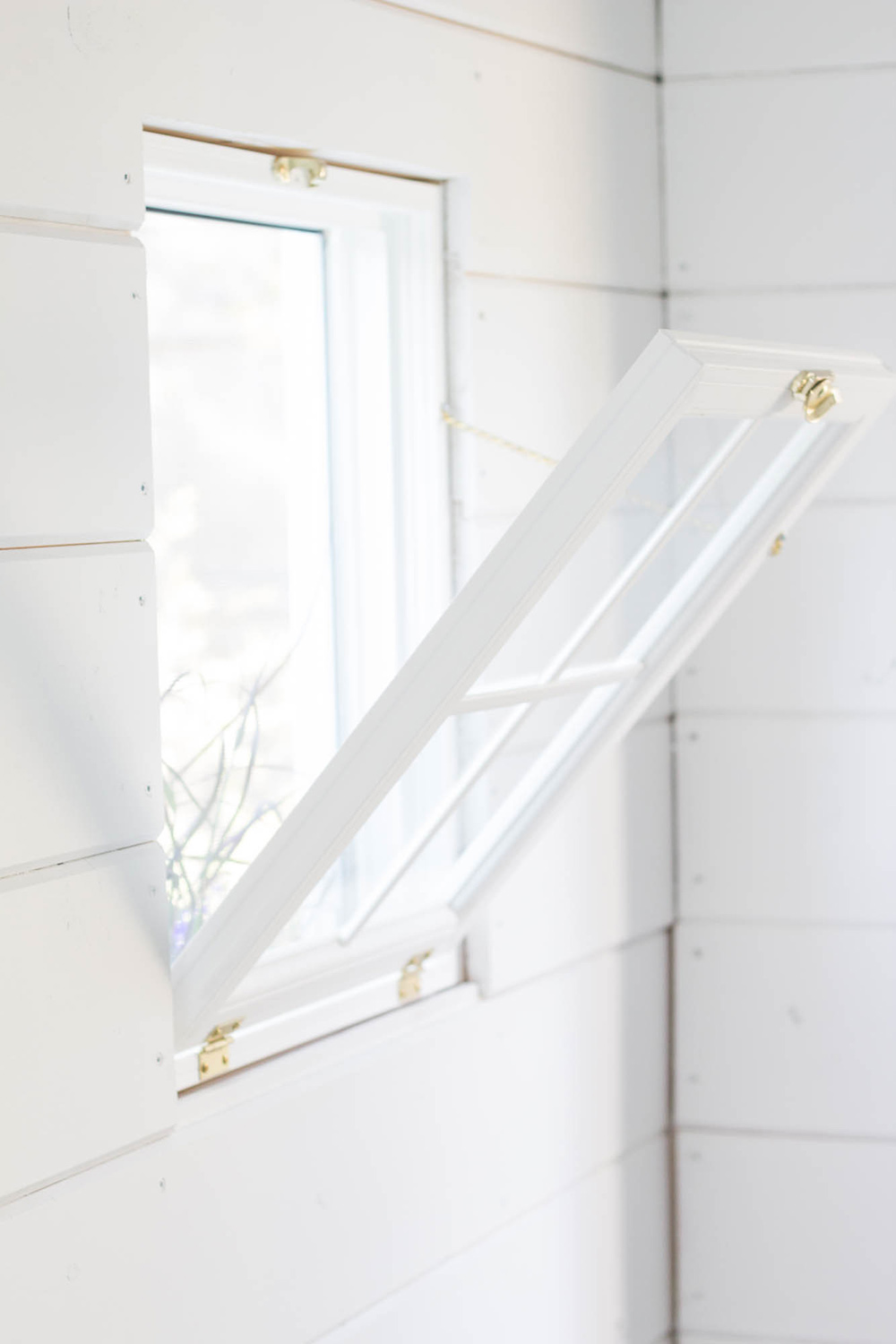 White shiplap walls with an open window. White shiplap walls with an open window.