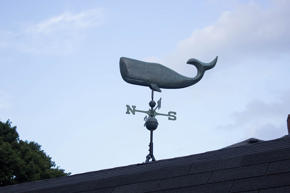 A copper whale weathervane attached to the roof of a "she shed". A copper whale weathervane attached to the roof of a "she shed".