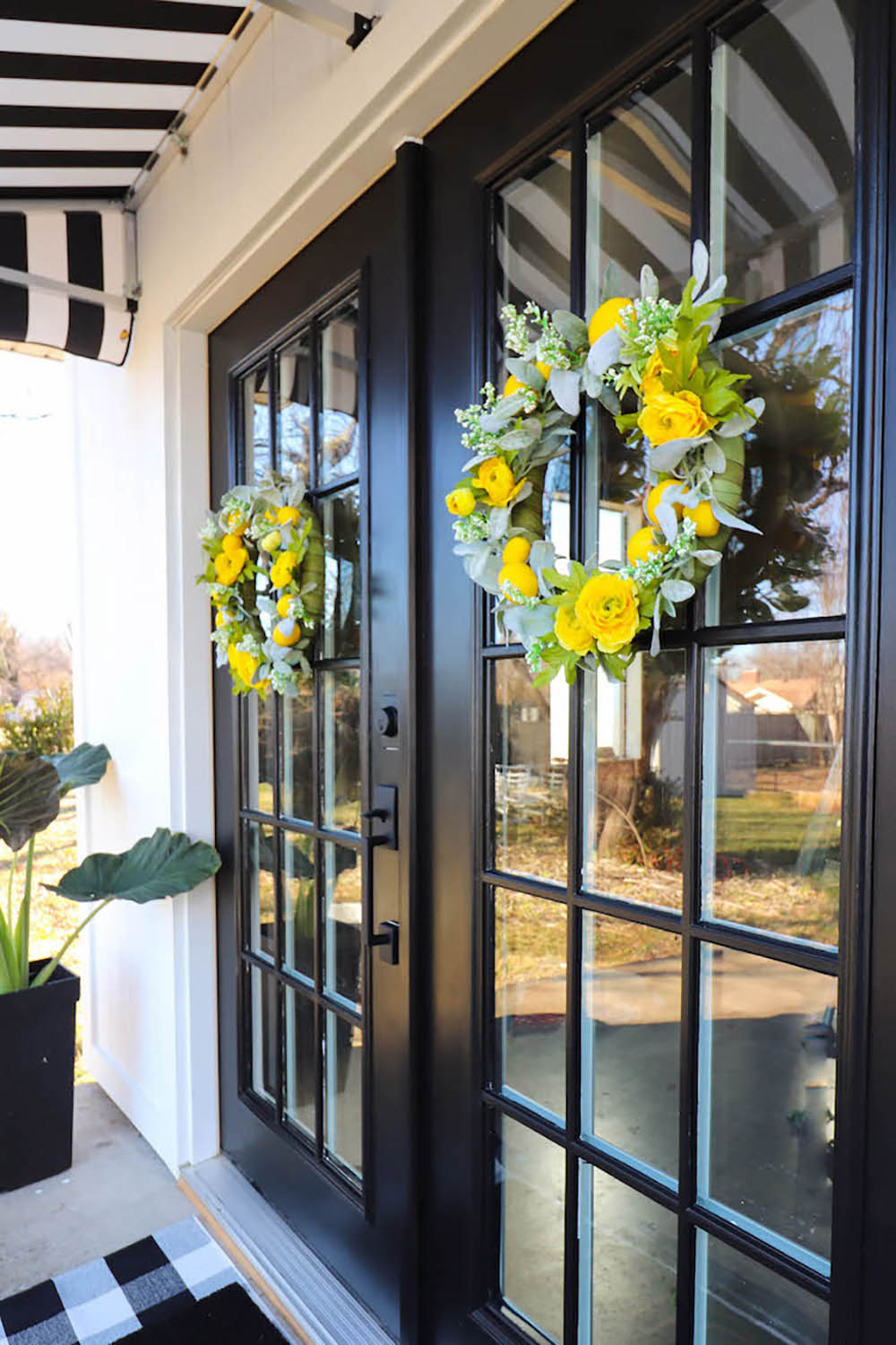 A set of black and glass patio doors with colorful wreaths.